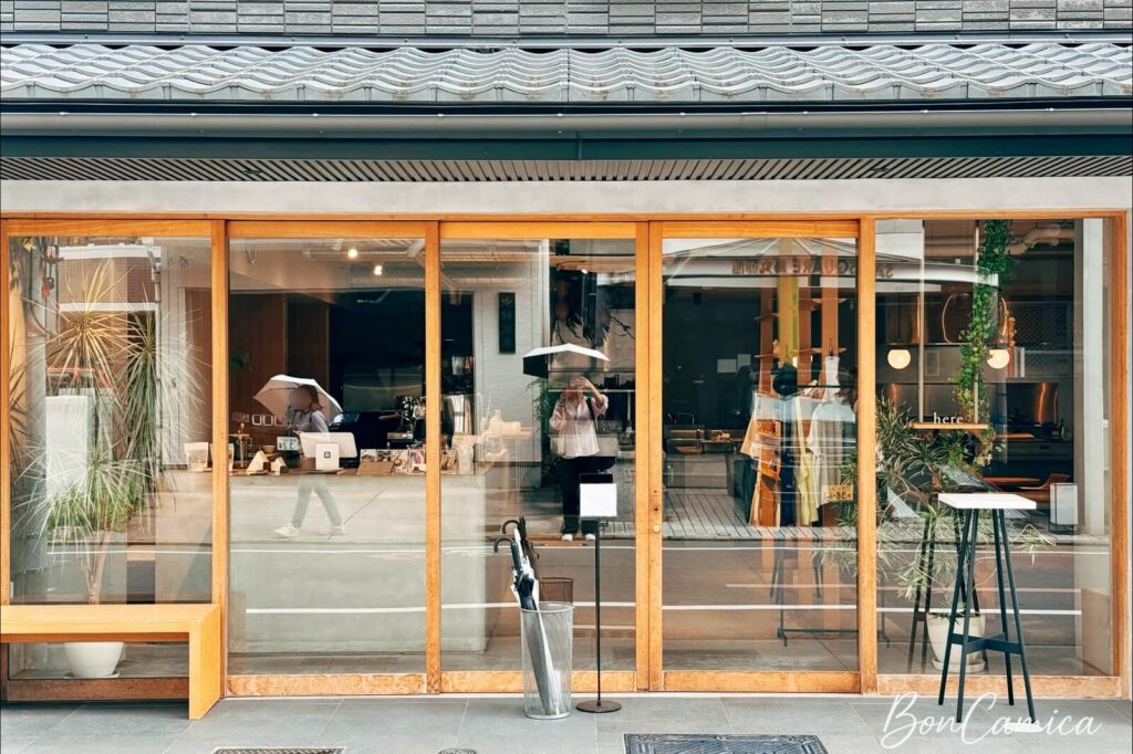 here 咖啡店正門外觀,推拉式木框落地玻璃門投射出通透採光