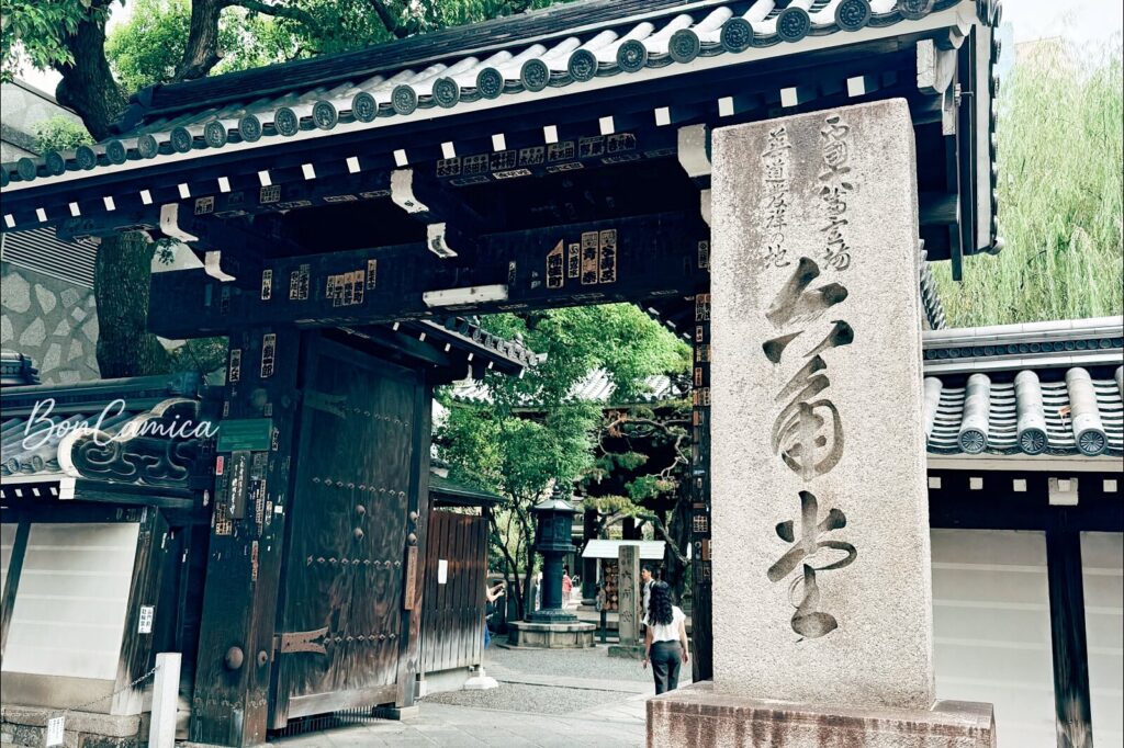 石碑上刻有漢字「六角堂」,木造大門入口與瓦片屋頂