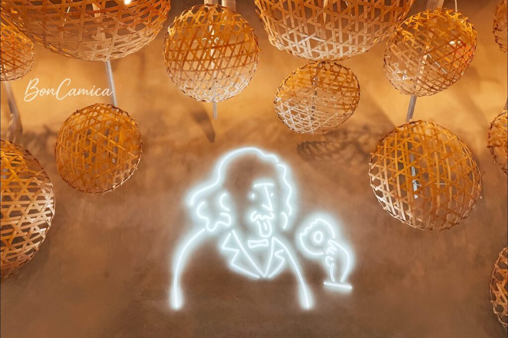 店內牆上的竹簍造型裝飾與 一個老先生在吃甜甜圈的 LOGO 圖案燈條