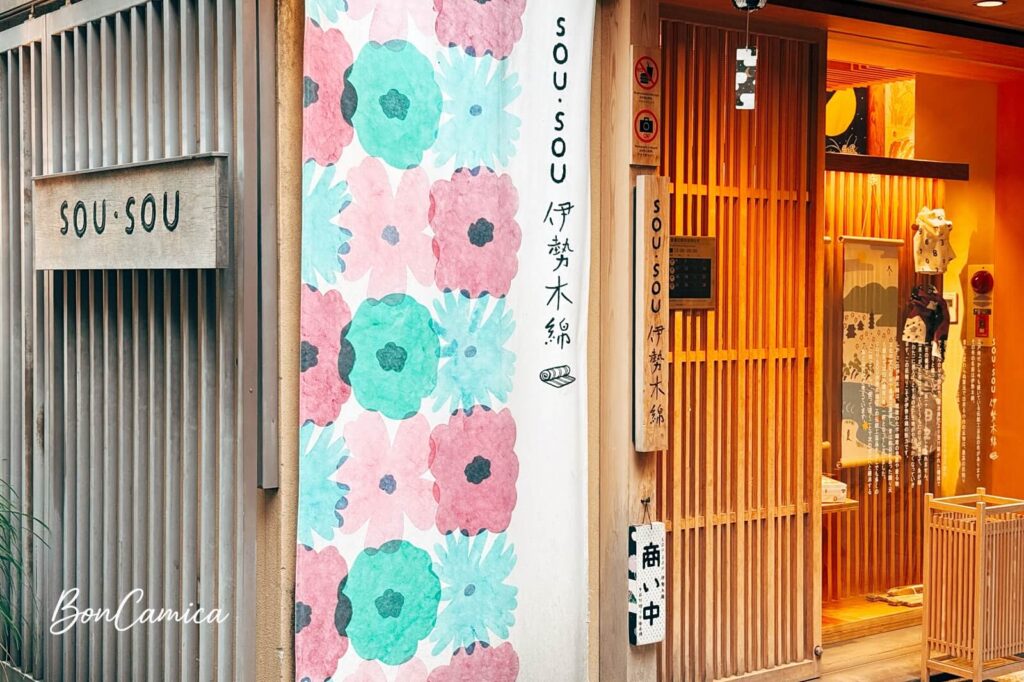 sou.sou 伊勢木綿店的日式傳統木造町家建築外觀與門口掛著的白底與藍綠紅色花朵圖案設計布簾