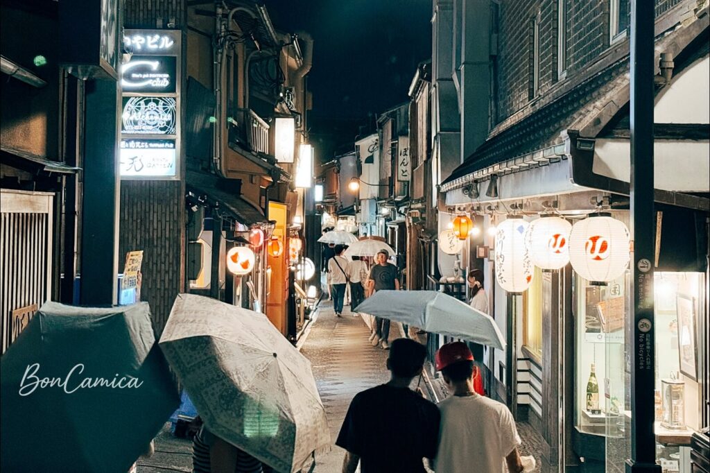 京都先斗町狹窄弄巷內掛飾傳統紙燈籠與人潮穿梭的夜間街景